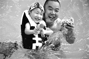 父子倆在水上樂園玩水槍